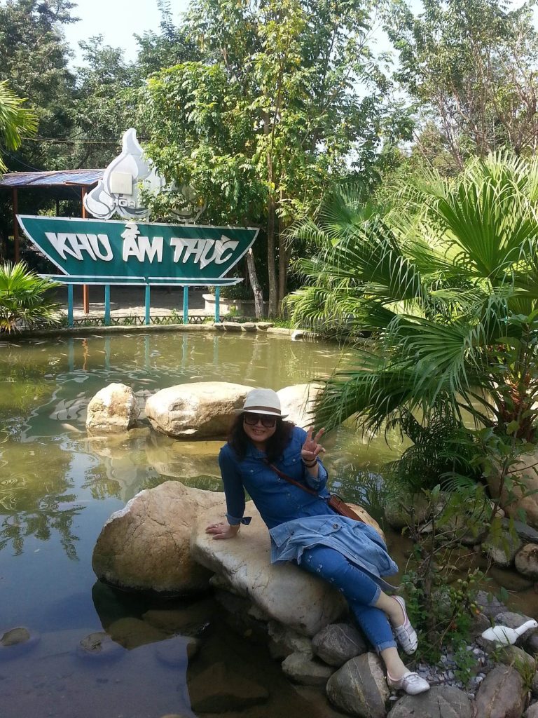 A woman sitting on a rock near Hoa Phu Thanh spring stream in the morning